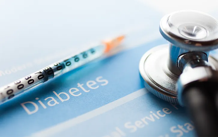Eine Spritze und Stetoskop auf etwas liegend wo Diabetes drauf steht