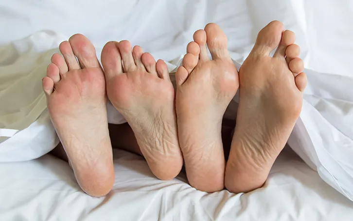 Vier Füsse die unter einer Decke raus schauen