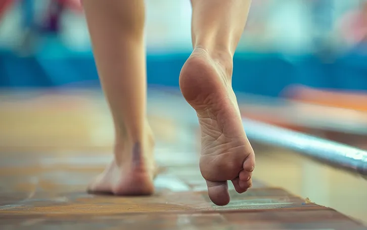 Eine Person mit nakten Füssen auf einer Web und sieht so aus, als würde er Anlauf nehmen